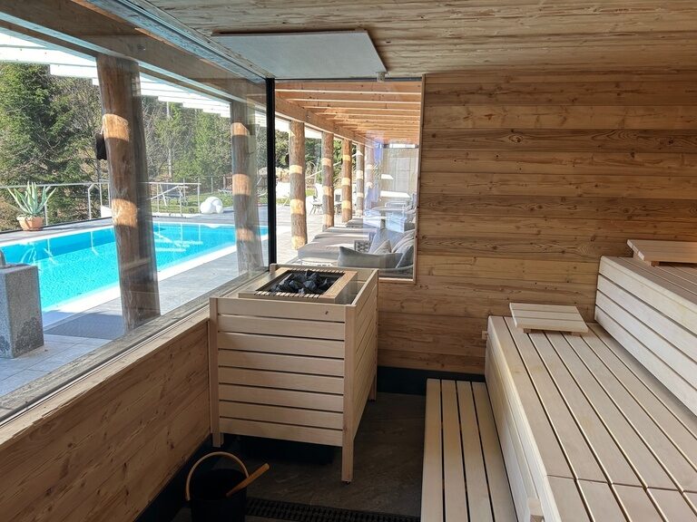 Die finnische Sauna ist ausgestattet mit Holzbänken und einem Saunaofen für einen perfekten Aufguss